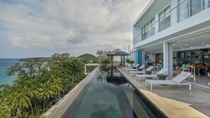 A modern infinity pool with clear water, lounge chairs, and a view of the ocean. - Bluesiam Villa (Choeng Thale)