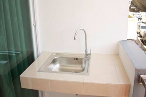 Uma cozinha pequena com pia, janela e vista para o exterior.