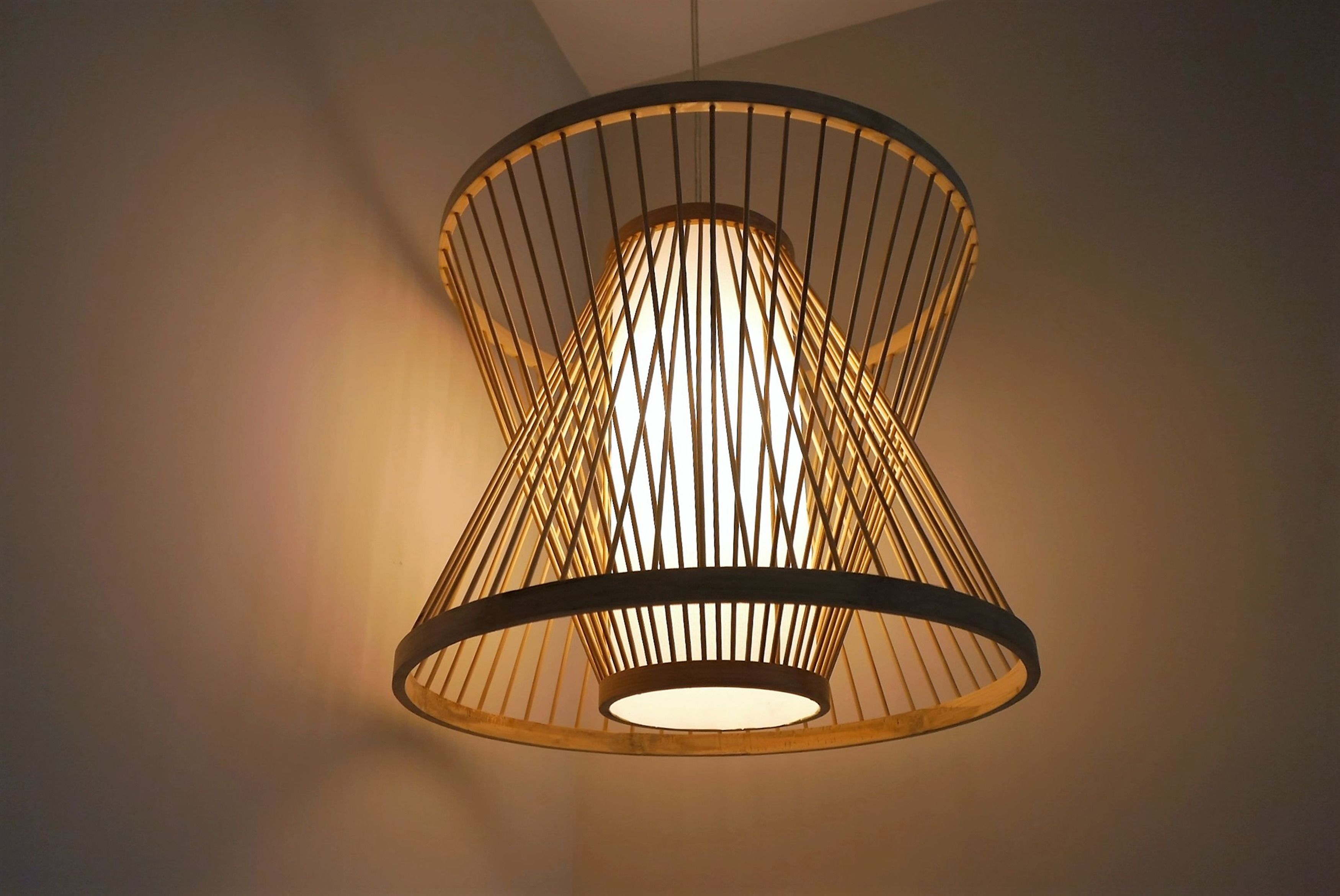 A pendant light fixture with a cylindrical shade and a metal frame.
