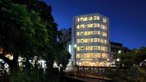 A multi-story building with illuminated windows and a bridge in the foreground. - SSBHotel - Shin Sei Bashi (Taichung)