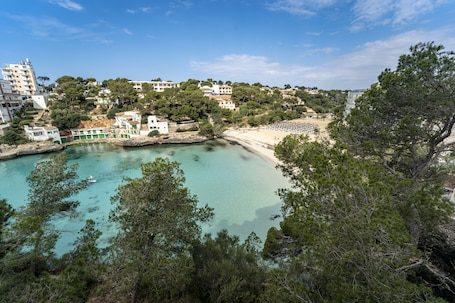 A coastal town with a beach, buildings, and a clear turquoise sea.