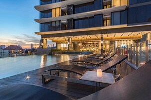 室外游泳池，池畔遮阳伞，日光浴躺椅