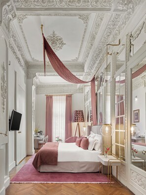 Une chambre à coucher comprenant un lit, un bureau, une chaise, un miroir et un téléviseur.