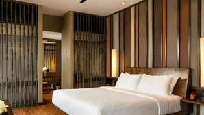 A modern hotel room with a large bed, wooden headboard, and a ceiling fan.