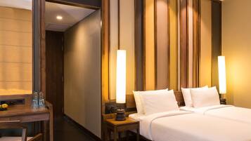A hotel room with a bed, bedside tables, a desk, and a mirror.