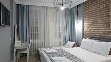 A hotel room with a bed, a desk, and a chair.