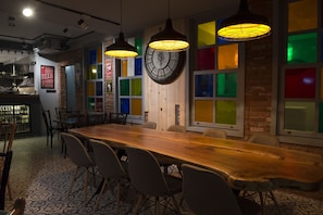 A long wooden table with wicker chairs, a large wall clock, and colorful stained glass windows. - Luna Boutique Hotel (Antalya)