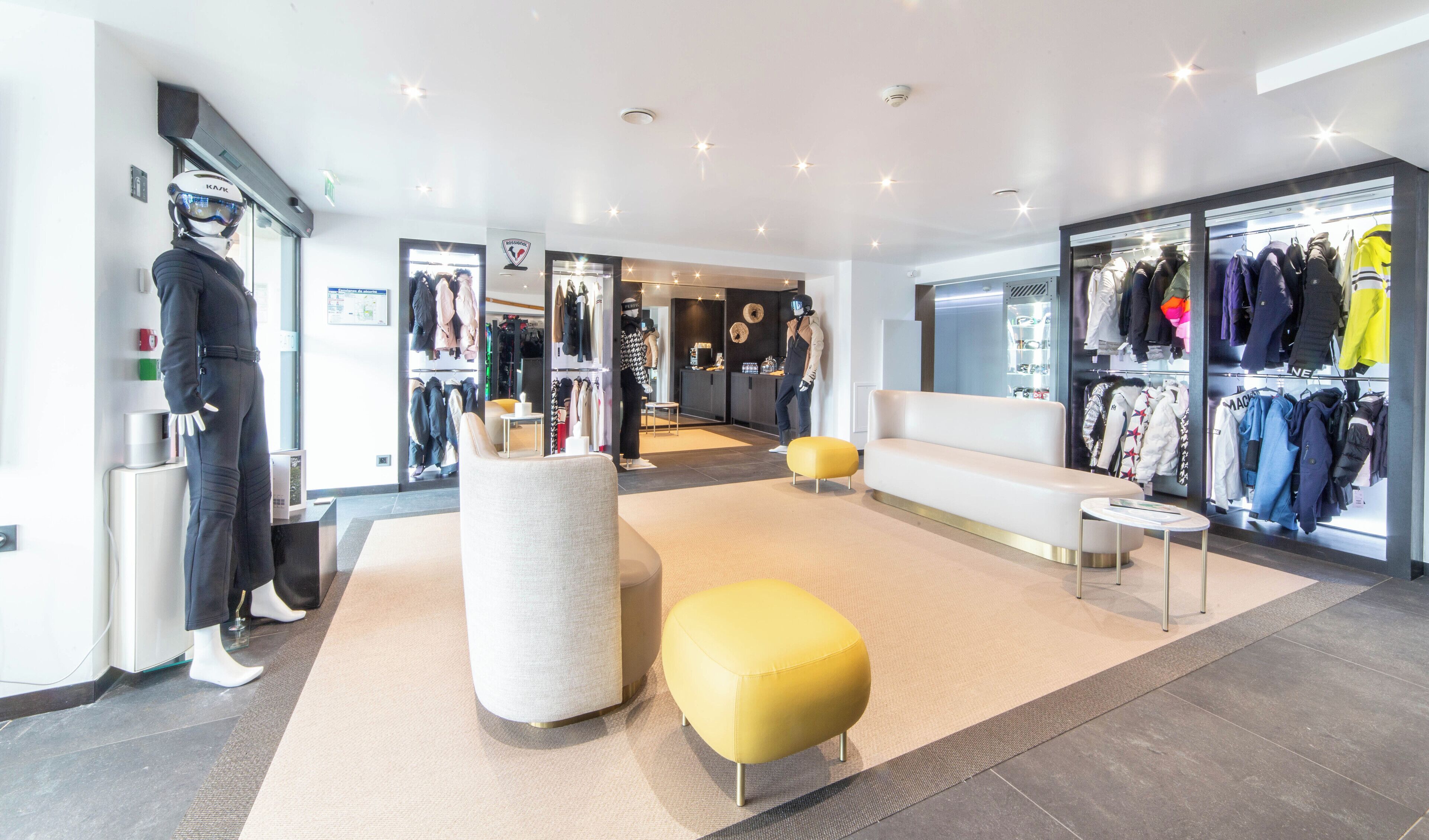 Un espacio comercial moderno con maniquíes, perchas para ropa y una zona de estar.
