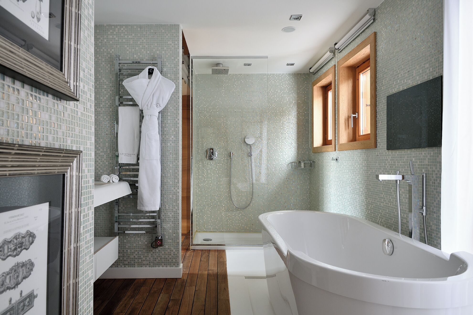 A modern bathroom with a freestanding bathtub, a glass-enclosed shower, and a wooden vanity.