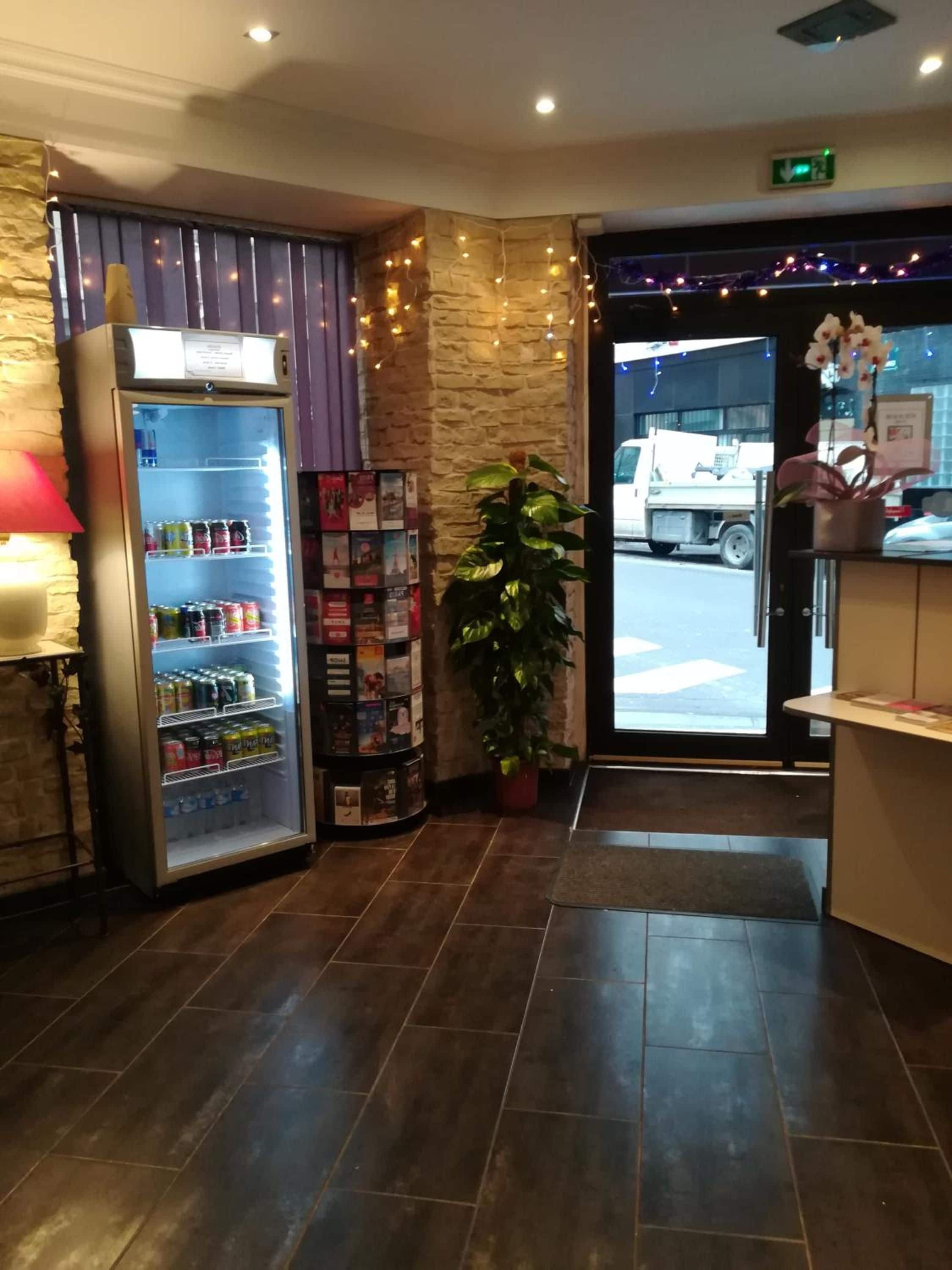 A reception area with a vending machine, a potted plant, and a display of magazines.
