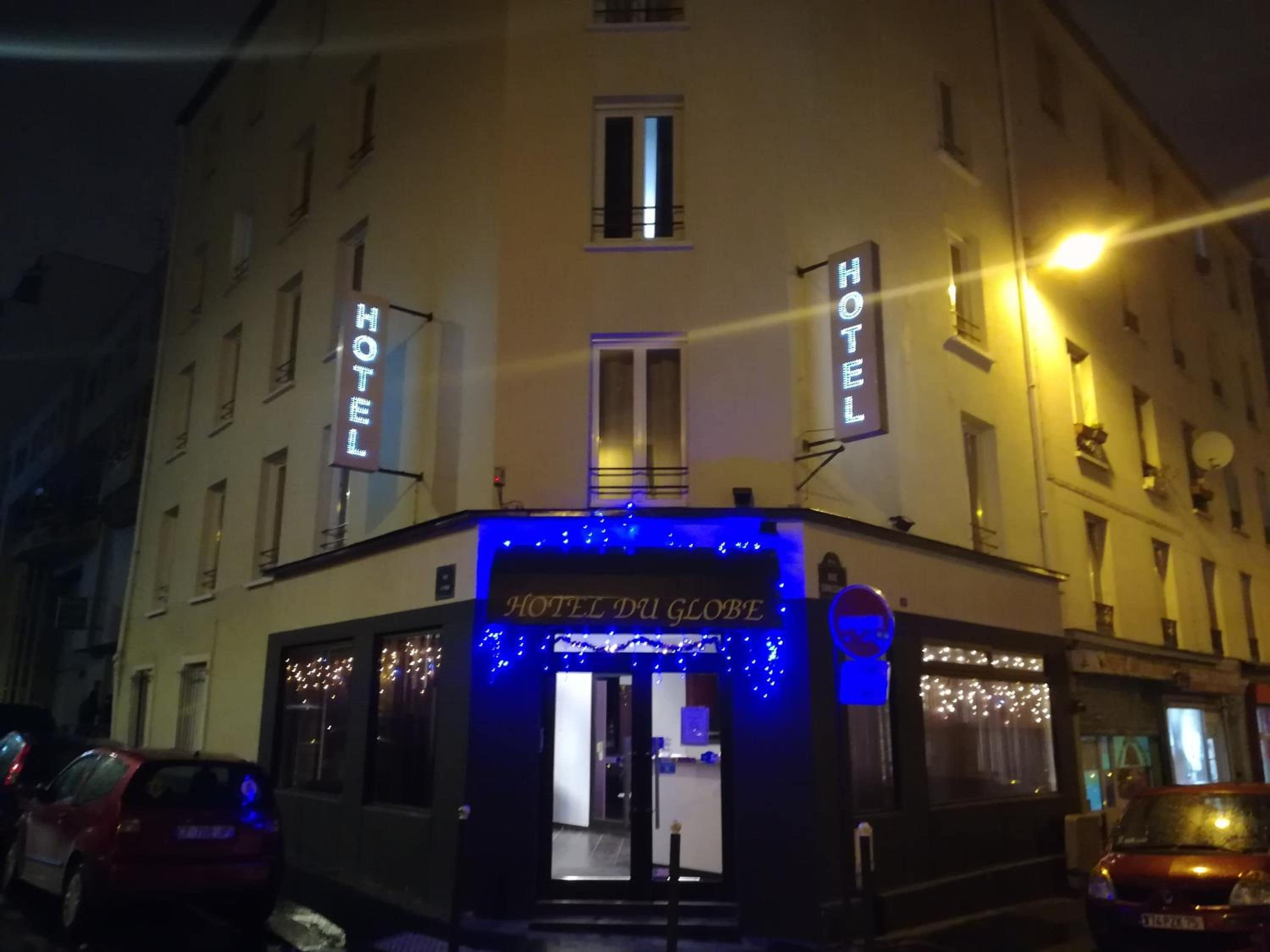 A hotel entrance with illuminated signage and a blue-lit facade.