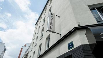 A hotel building with a sign indicating 'HOTEL' on the facade.