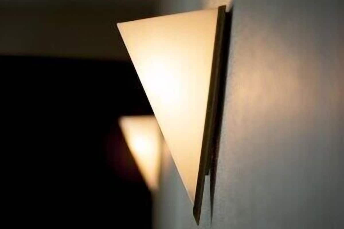 A wall-mounted light fixture with a triangular design.