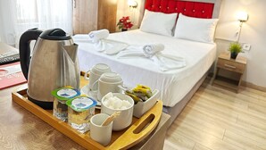 A hotel room with a bed, bedside lamps, a tray with food items, and a kettle. - Taksim Park  (Istanbul)