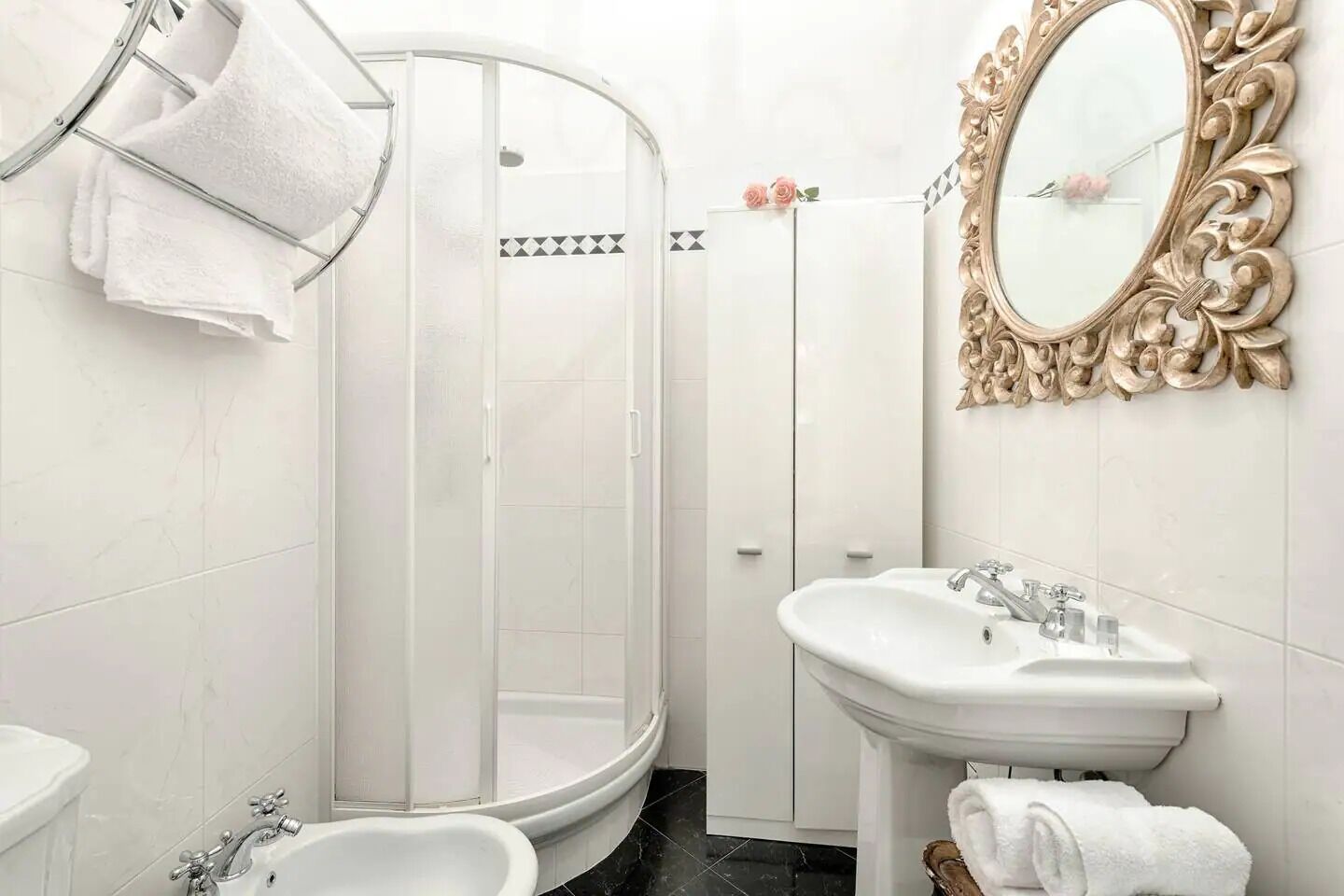 A bathroom with a shower, sink, and mirror.