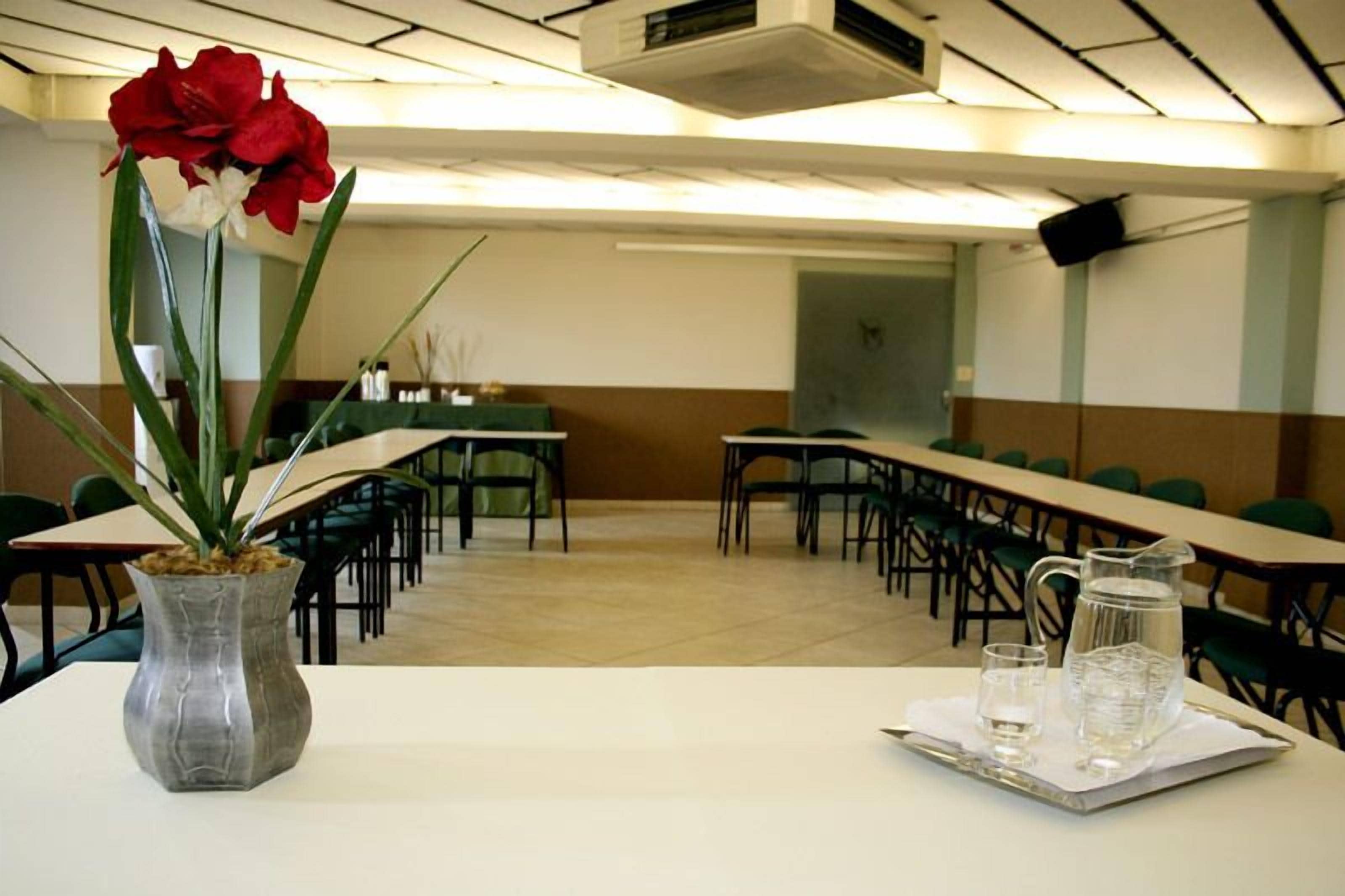 A conference room with tables, chairs, and a water pitcher on a tray.