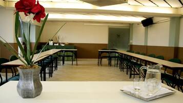 A conference room with tables, chairs, and a water pitcher on a tray.