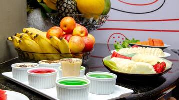 A fruit bowl with bananas, apples, and a pineapple.