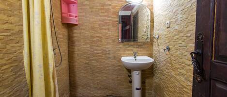 A bathroom with a tiled floor, a sink, a mirror, and a shower curtain.