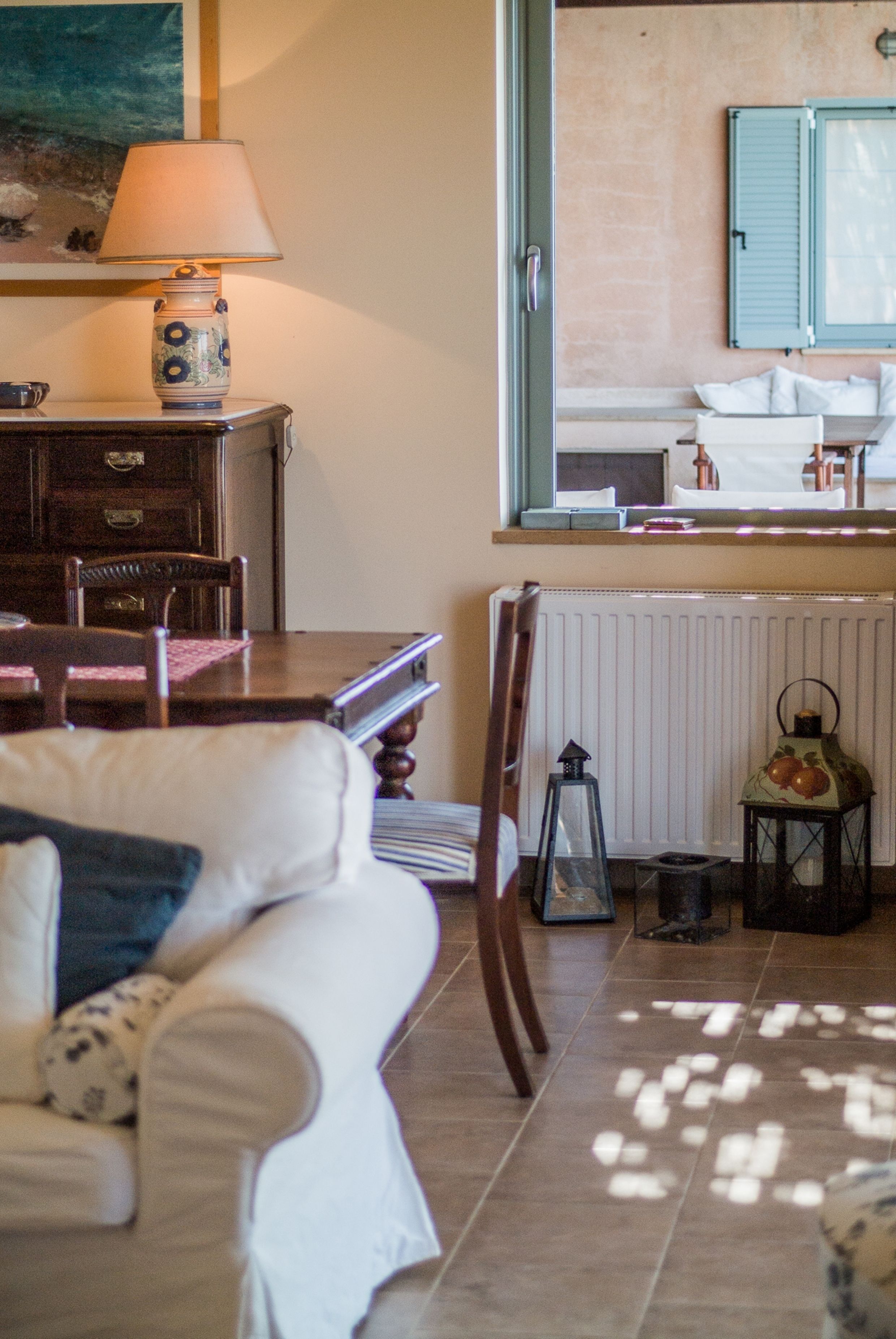 A cozy living room with a sofa, a dining table, and a lamp.
