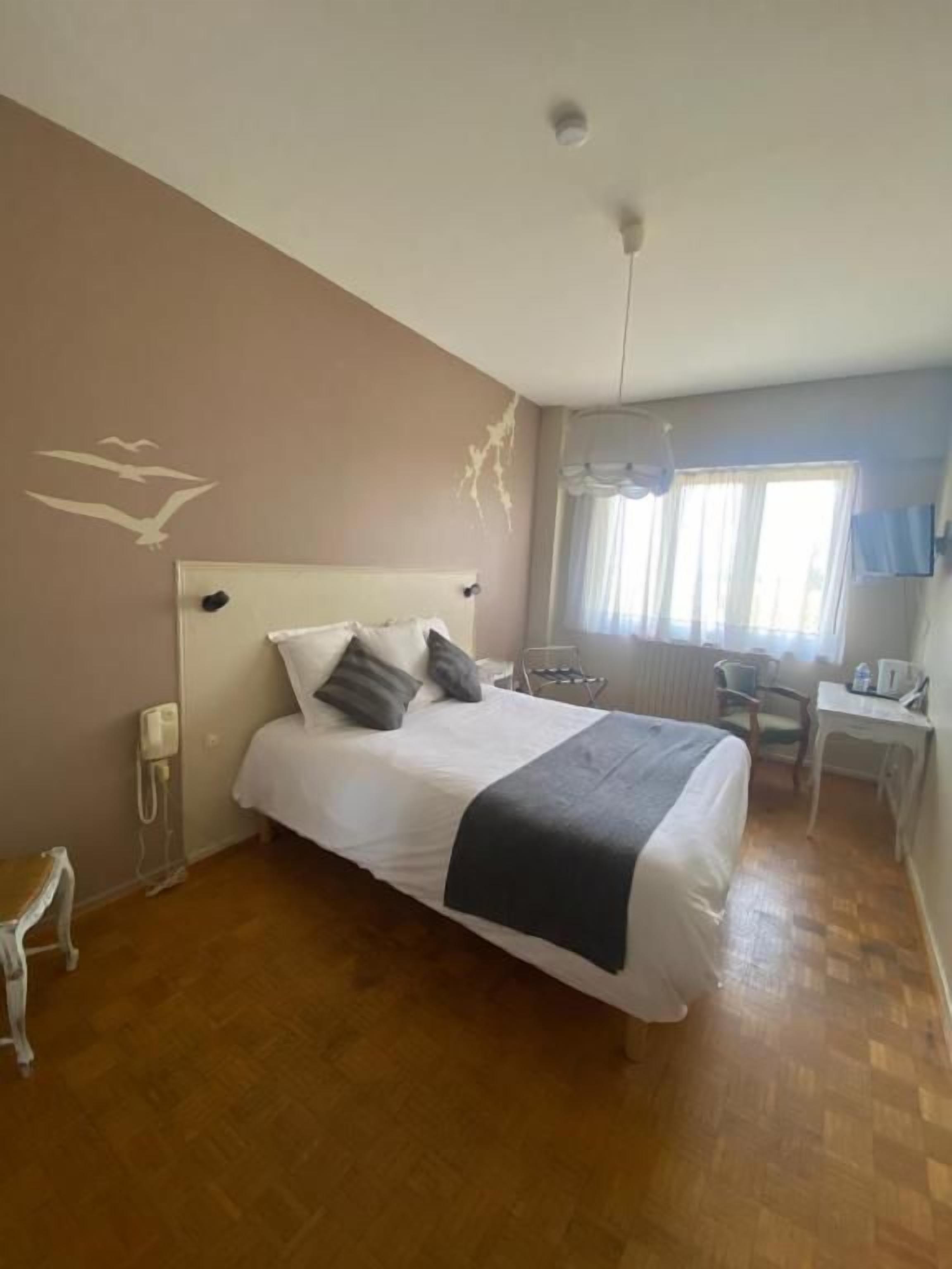 Un dormitorio con una cama, un escritorio y una silla.