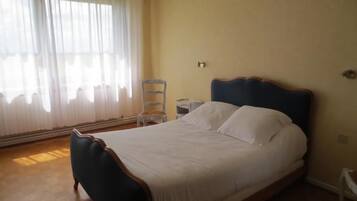 Une chambre à coucher avec un lit, une chaise et une table de chevet.