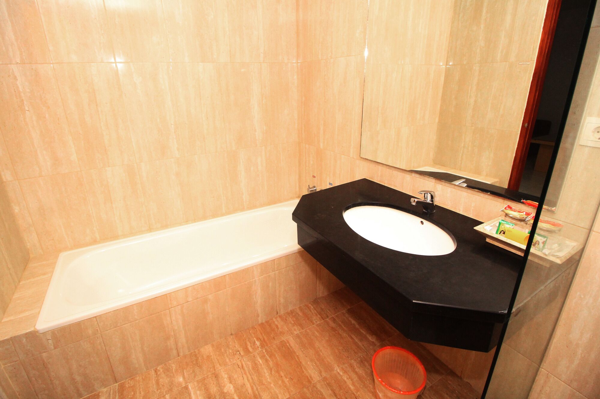 A bathroom with a bathtub, a sink, and a mirror.