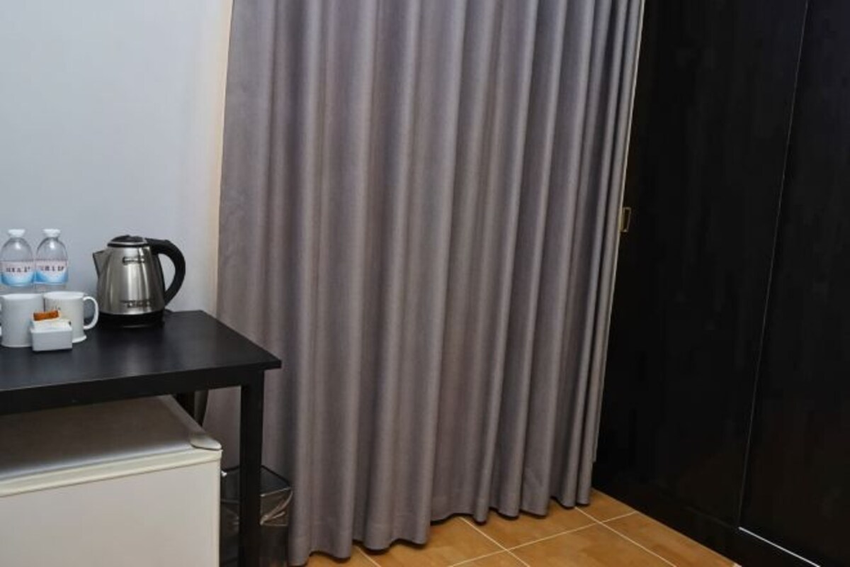 A room with a table, a kettle, and two bottles of water.