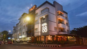 A multi-story hotel with a prominent 'HOTEL 88' sign, featuring a modern architectural design with balconies and a well-lit entrance. - Hotel 88 Diponegoro (Jember)