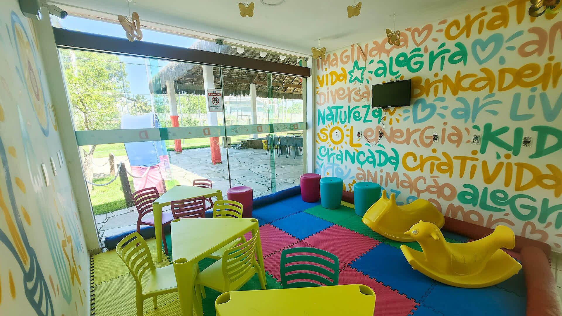 A brightly colored indoor play area with colorful chairs and a play mat.