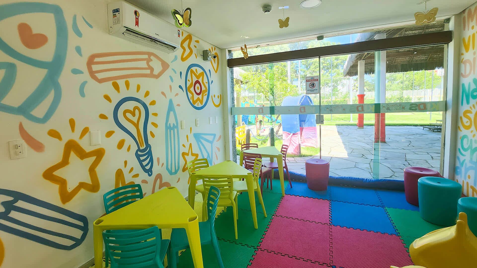 A brightly colored indoor play area with colorful walls, tables, and chairs.