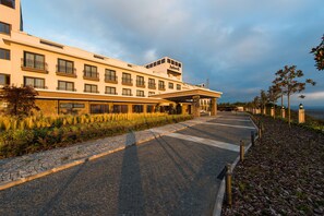 Stunning hotel facade with a symmetrical design, featuring balconies on each floor and a covered entrance area.