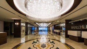 A spacious lobby with a reflective floor, a large chandelier, and a reception desk. - Radisson Blu Hotel, Ordu (Ordu)
