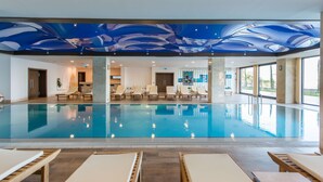 A large indoor swimming pool with lounge chairs and a ceiling mural. - Radisson Blu Hotel, Ordu (Ordu)