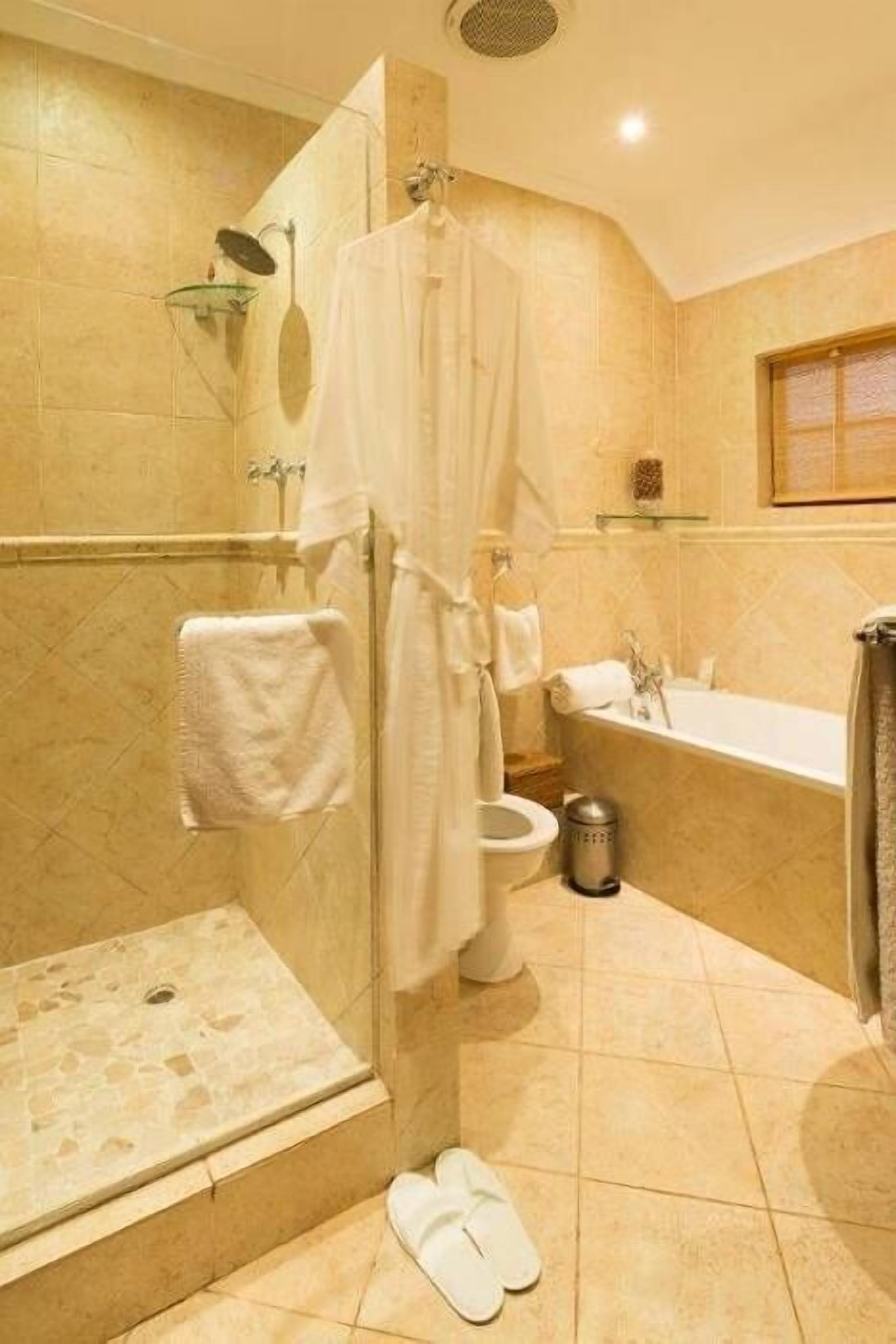 A bathroom with a shower, toilet, and bathtub.