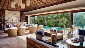 A spacious lounge area with wicker furniture, a bar, and a large window overlooking a pool and tropical landscape. - Casa Chablé Sian Ka'an Reserve - South of Tulum (Punta Allen)