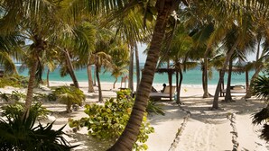 A beach with palm trees, a sandy path, and a beach chair. - Casa Chablé Sian Ka'an Reserve - South of Tulum (Punta Allen)