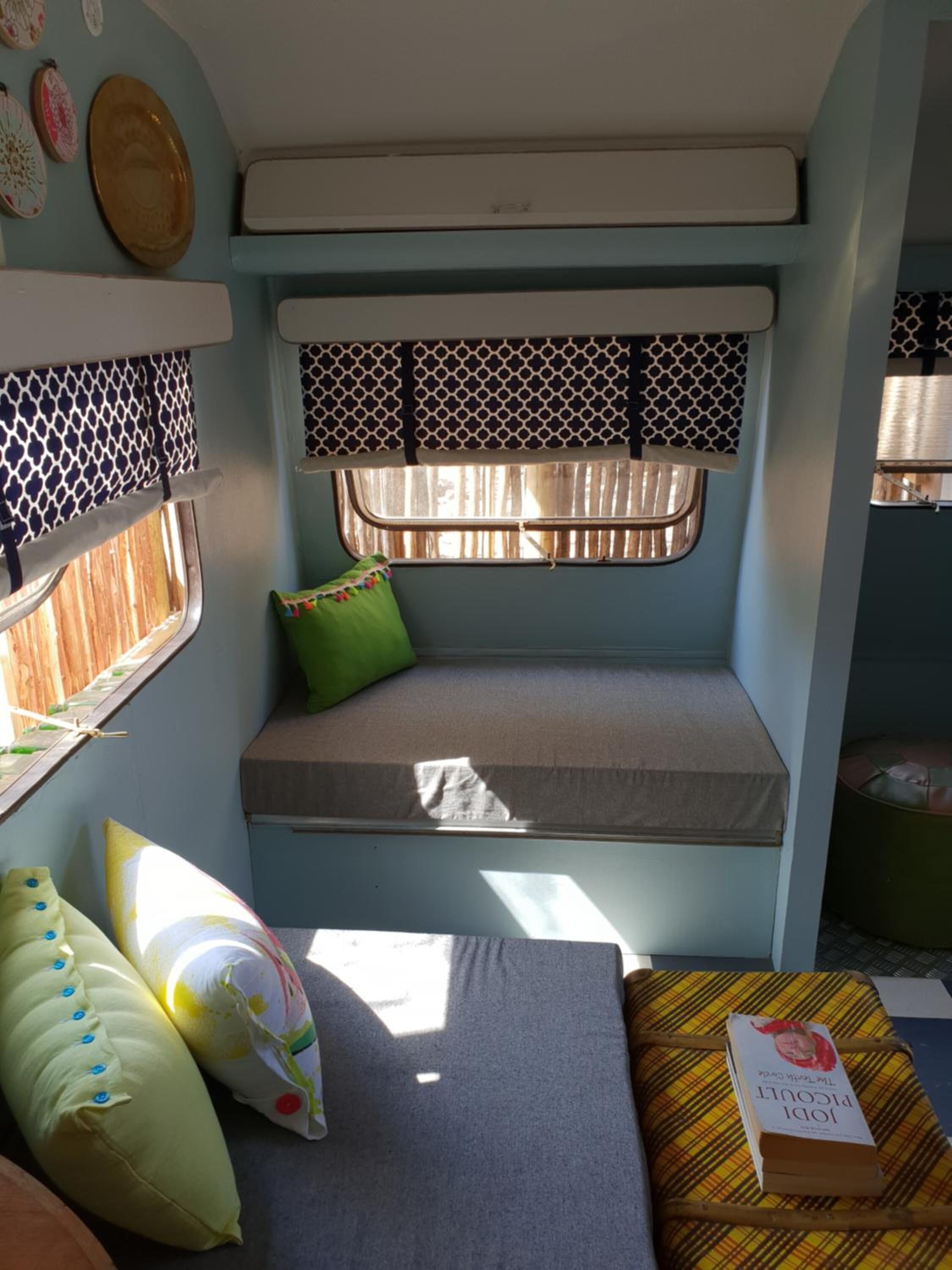 A cozy interior with a bench seat, pillows, and a book on a table.