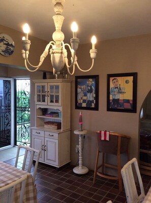 A dining area with a chandelier, a cabinet with glass doors, a table with chairs, and artwork on the walls. - Hamelin Guest House (Bluff)