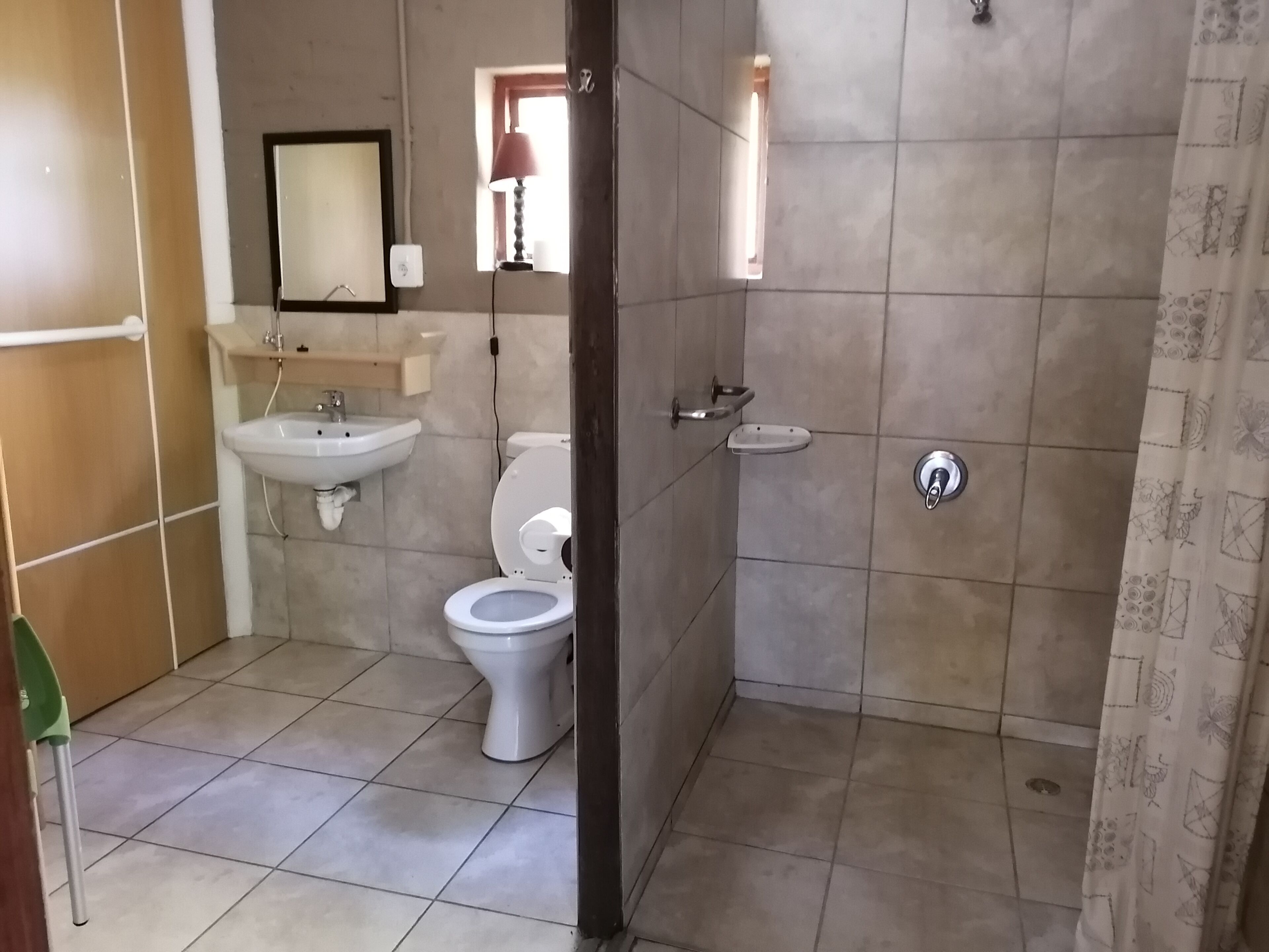 A bathroom with a toilet, sink, and shower area.