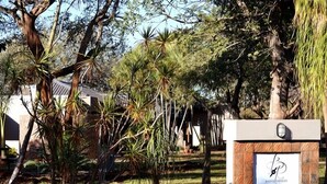 A landscaped area with various trees and a signboard. - Barnstormers Rest (Nkomazi)
