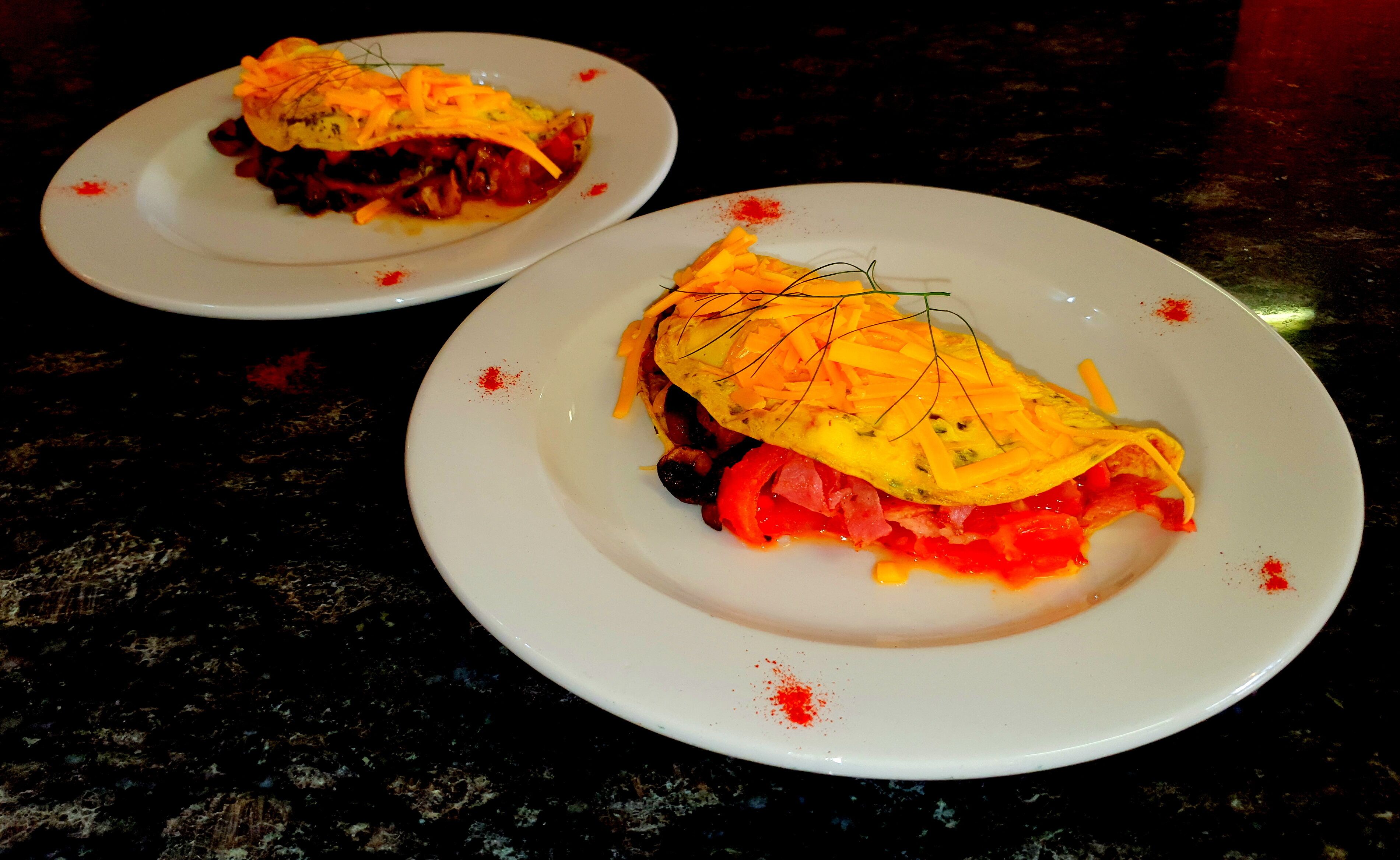 Deux assiettes de nourriture sur un plan de travail sombre.