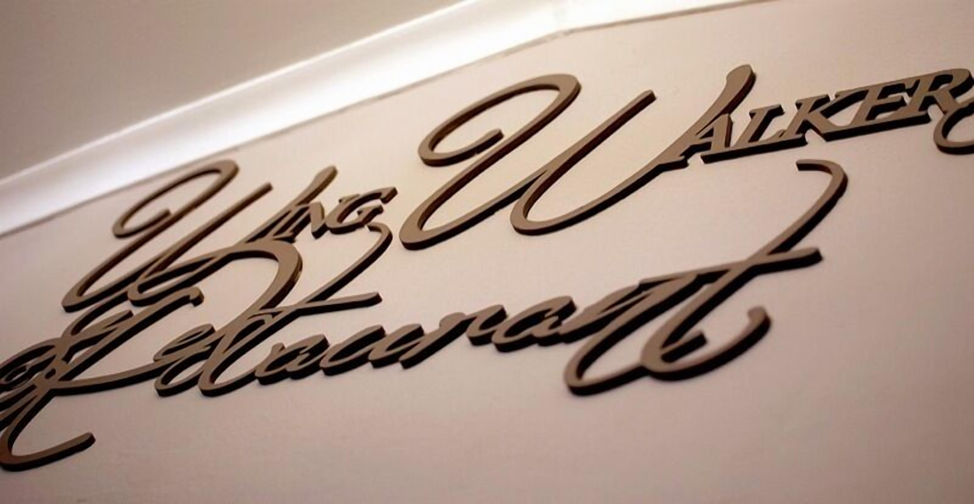 A wall with the name "The Walker" in a cursive, metallic font.
