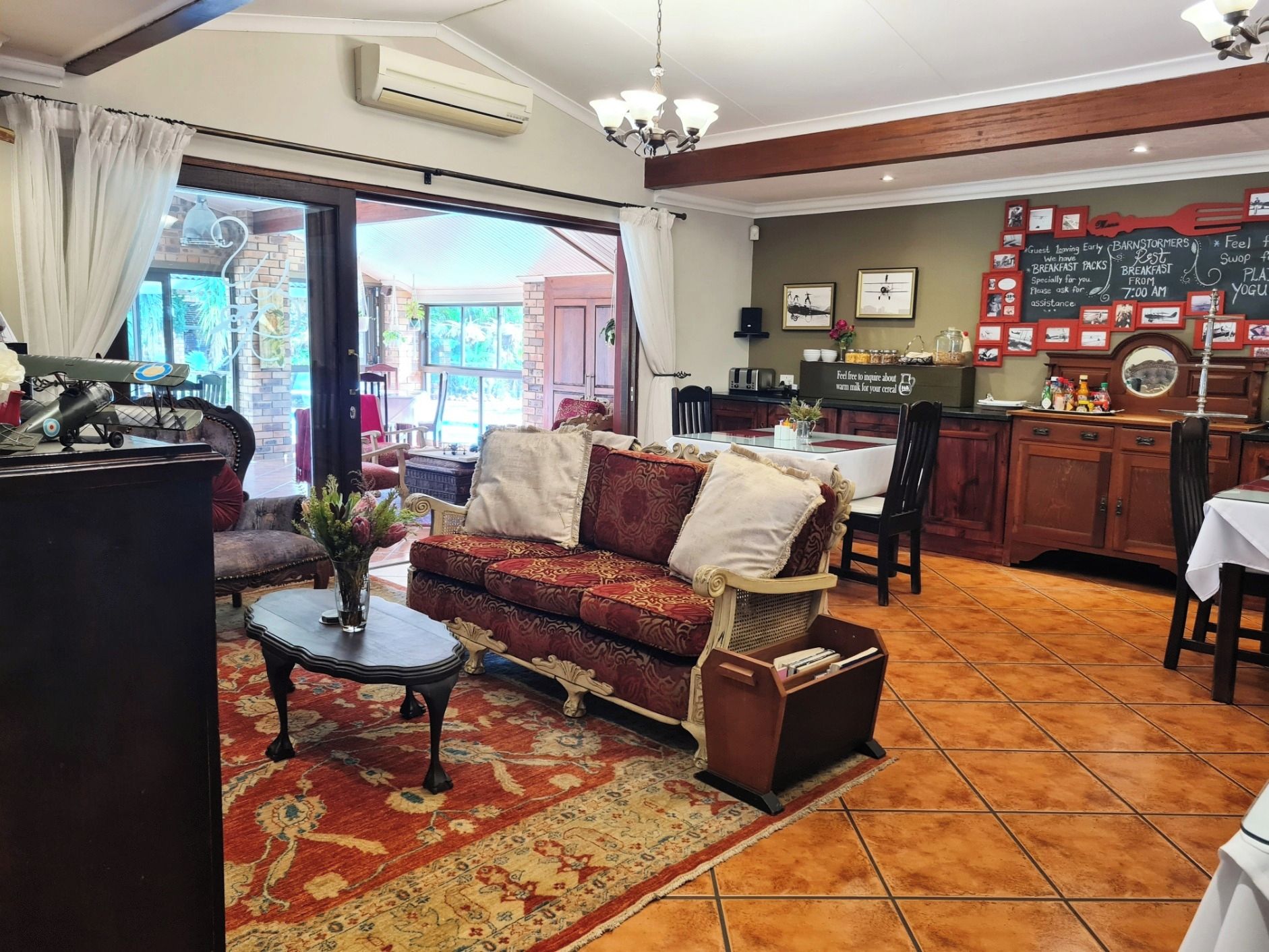 Un salon chaleureux avec un canapé, une petite table et un vase décoratif.