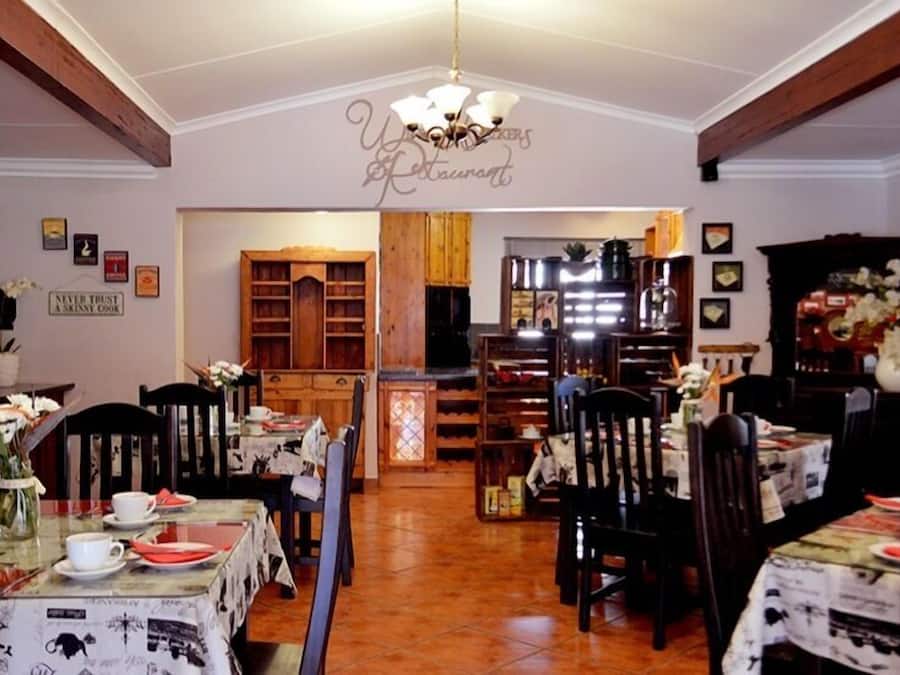Un restaurant avec des meubles en bois, un lustre et une enseigne sur laquelle on peut lire : « Ne faites jamais confiance à un cuisinier maigre. »