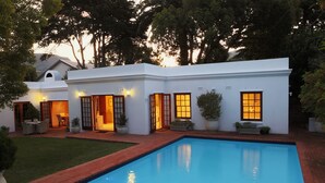 A modern house with a swimming pool, a patio, and a well-maintained lawn. - Constantia Garden Suites (Cape Town)