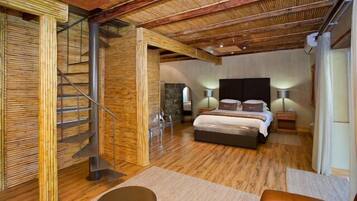 Un dormitorio amplio con una cama grande, una escalera de madera y un diseño moderno.