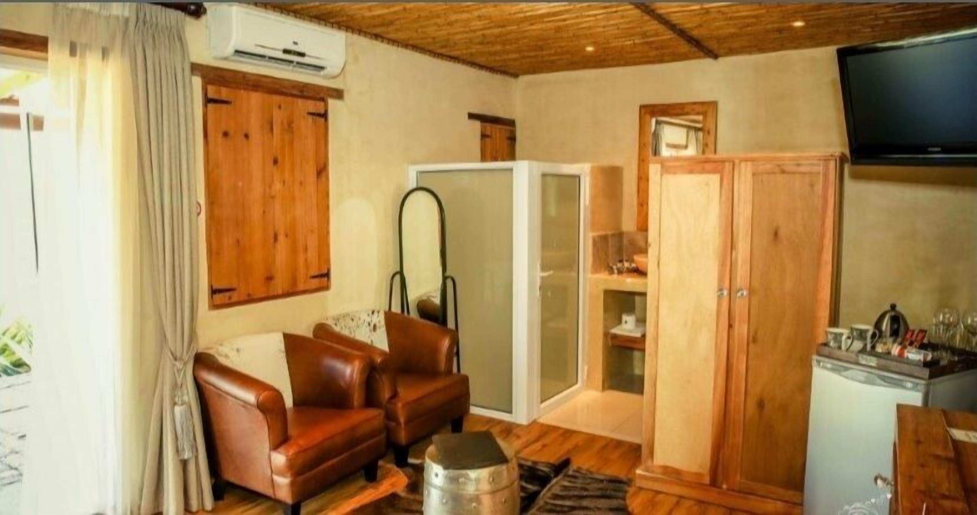 Une pièce chaleureuse avec un plafond en bois, un canapé, une armoire et un téléviseur.
