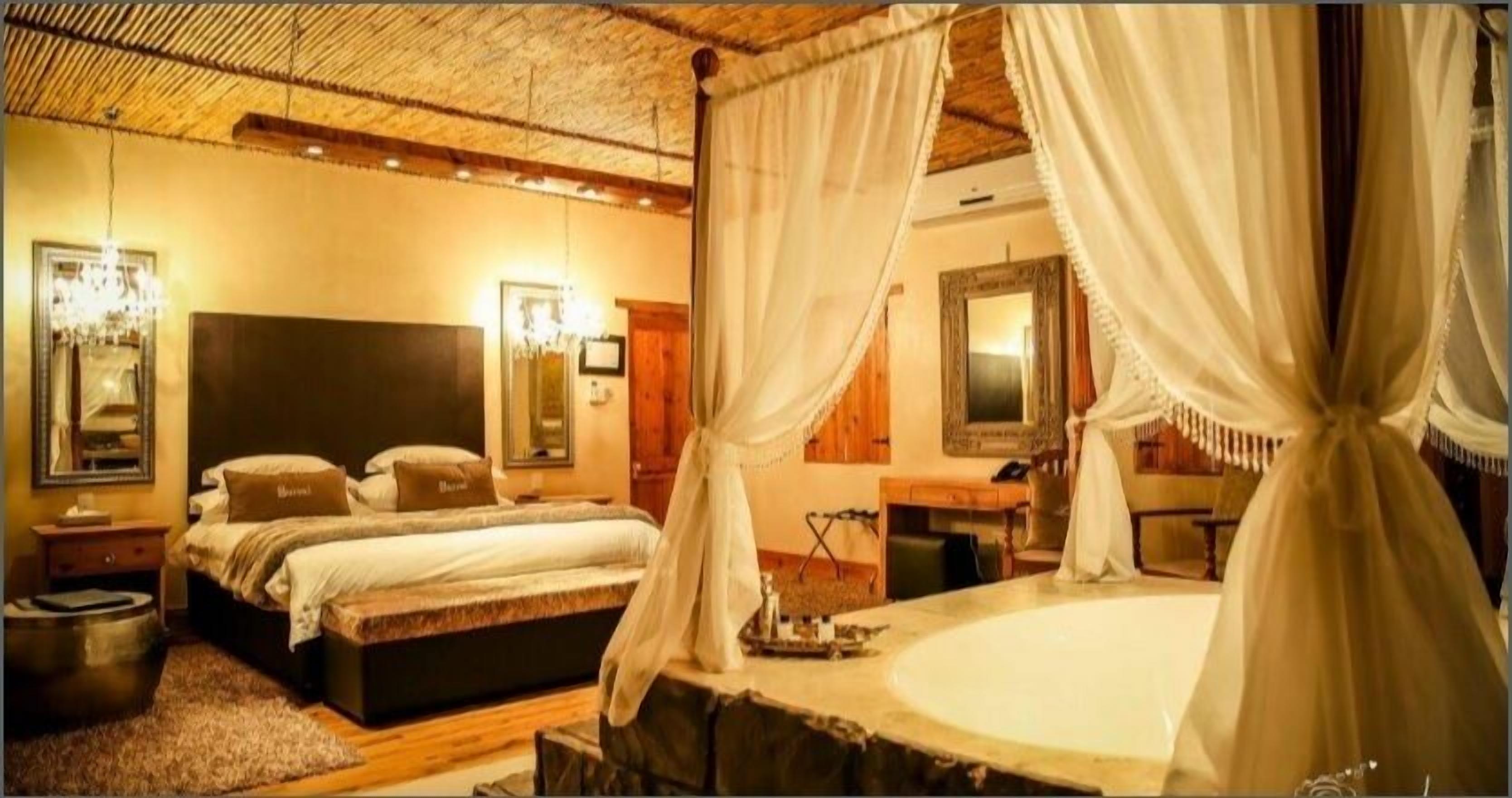 A bedroom with a large bed, a bedside table, a mirror, and a canopy bed.