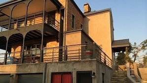 A two-story building with a balcony, a staircase, and a garage. - The Warehouse (Krugersdorp)